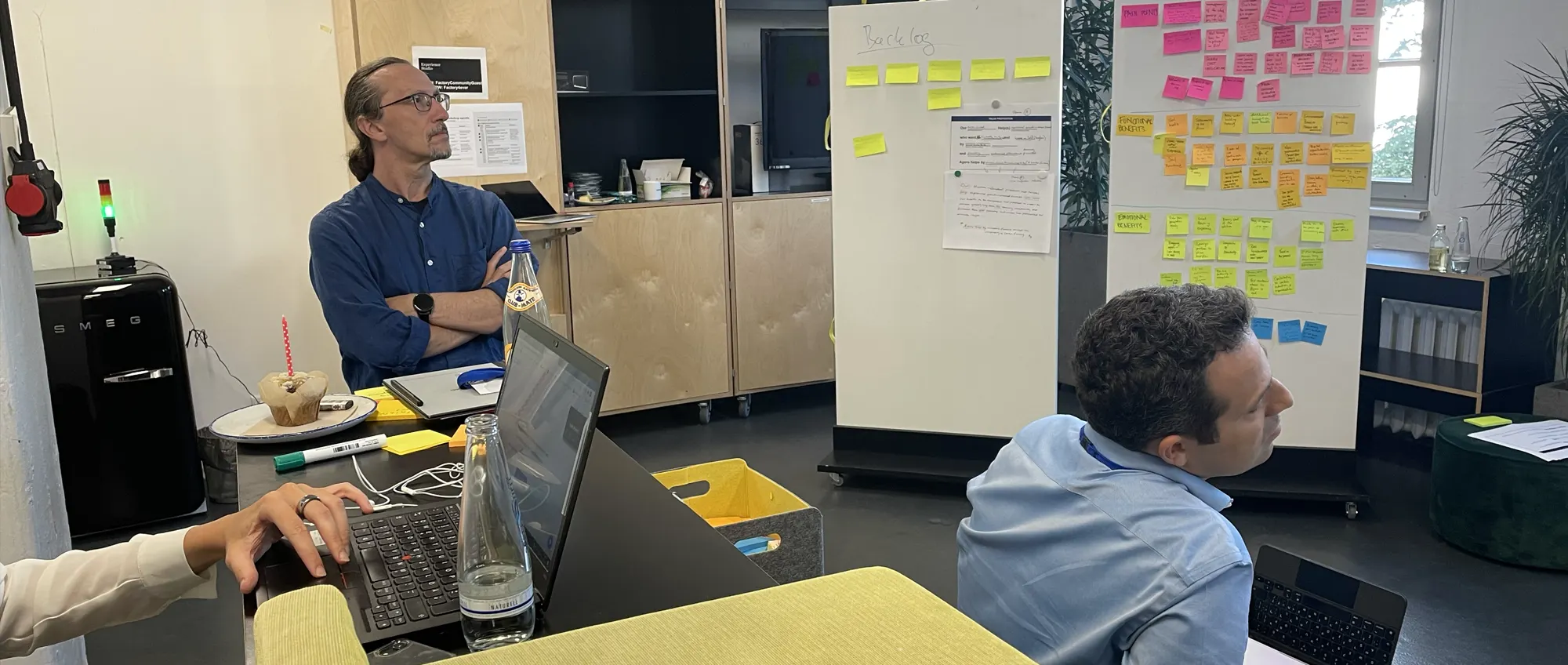 A design team working around whiteboards covered in sticky notes